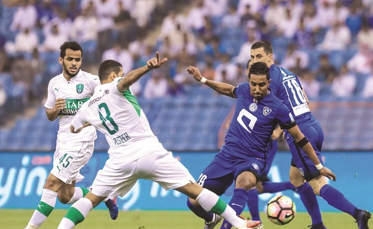 لاعب الاهلي تيسير الجاسم يقطع الكرة من لاعب الهلال سالم الدوسري ﻿
