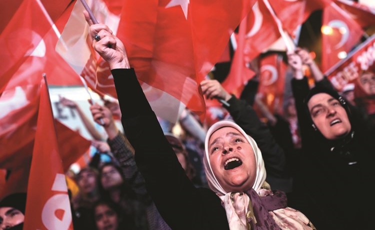 اتراك يلوحون بعلم بلادهم ابتهاجا عقب اعلان نتيجة الاستفتاء امام مقر الحزب الحاكم في اسطنبول امس الاول (أ.ف.پ)﻿
