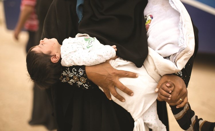 عراقية تحمل رضيعها خلال فرارها من القتال الدائر في الموصل امس	 (أ. پ)﻿