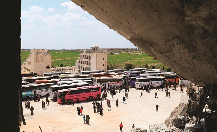 نقطة تجمع الحافلات التي تقل الخارجين من كفريا والفوعة في منطقة الراشدين في طريقها الى مناطق سيطرة النظام(رويترز)﻿