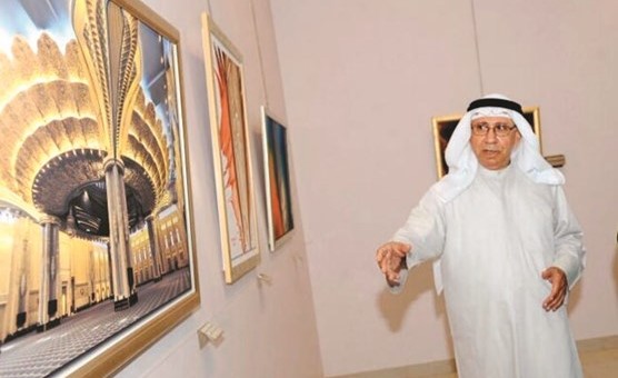 الفنان جواد النجار مع إحدى لوحاته ﻿
