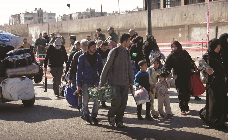 الدفعة السادسة من مهجري الوعر يستقلون الحافلات في طريقهم للمغادرة الى جرابلس أمس(أ.پ)﻿