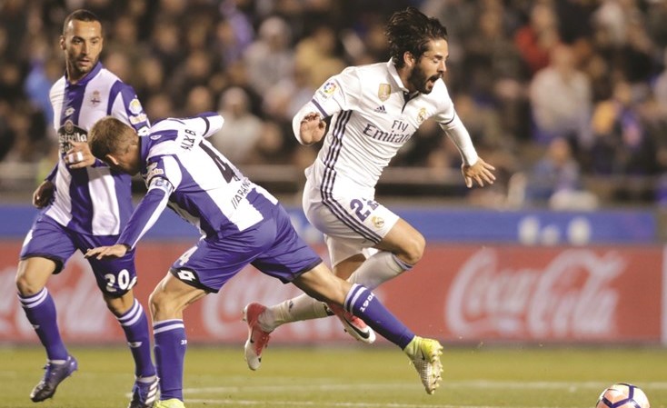 نجم ريال مدريد ايسكو يحاول تجاوز مدافع ديبورتيفو لا كورونيا(رويترز)﻿