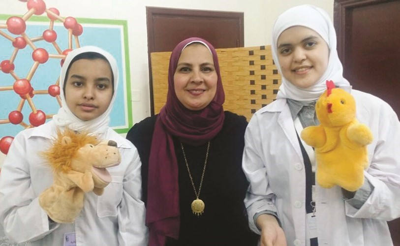 غادة عبدالمنعم تتوسط الطالبتين موضي الظفيري ومريم الخالدي﻿