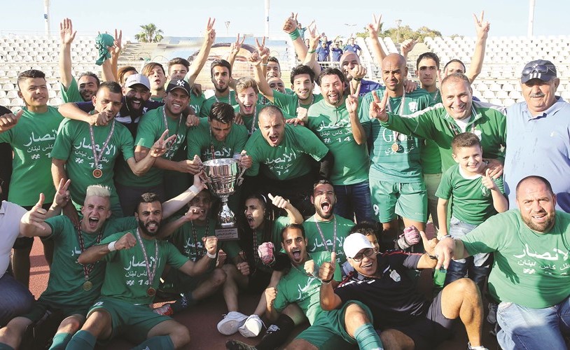 لاعبو فريق الأنصار فرحين بالكأس ﻿