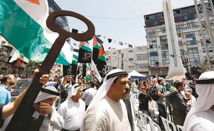 فلسطينيون يرفعون مفتاحا رمزيا لتأكيد تمسكهم بحق العودة خلال مظاهرات لاحياء ذكرى النكبة في رام الله امس ( رويترز)﻿