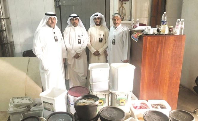 فريق البلدية وأمامهم كمية المواد الغذائية الفاسدة﻿