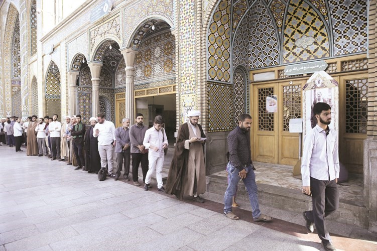 ايرانيون يصطفون في طابور طويل امام احد مراكز الاقتراع في مدينة قم امس	(ا.پ)