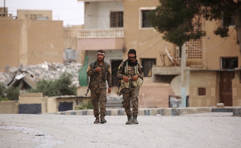 أعضاء من القوات الديموقراطية السورية يسيرون في الطبقة أمس	(أ.ف.پ)﻿