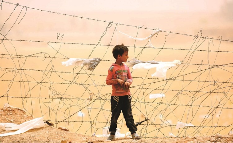 ﻿طفل سوري هارب من سيطرة داعش في الرقة يراقب عاصفة رملية في مخيم عين عيسى	(ا.ف.پ) ﻿