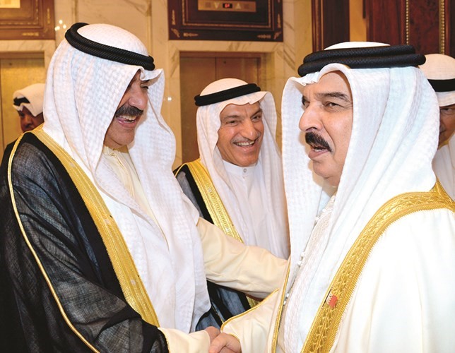 ملك البحرين مصافحا خالد الجارالله ويبدو المستشار محمد أبو الحسن﻿