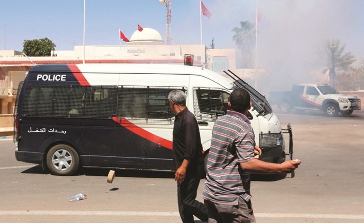 تونسيون عاطلون عن العمل يلقون الحجارة على مقر محافظة تطاوين خلال تظاهرة احتجاجية امس(أ.ف.پ) ﻿