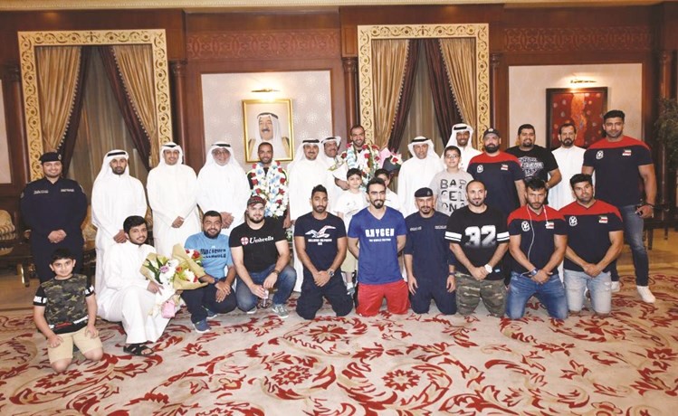 اللواء الانصاري في لقطة تذكارية مع البطلين اللذين يتوسطان رجال الإطفاء ﻿