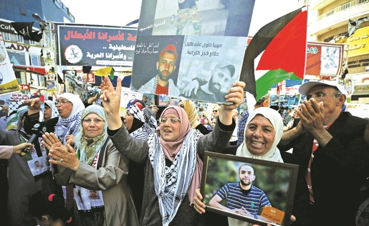 فلسطينيون يعربون عن فرحتهم بإنهاء الأسرى اضرابهم عن الطعام خلال مسيرة تضامنية في رام الله امس الاول	( رويترز)﻿