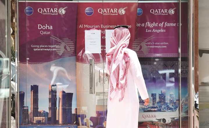 سعودي يمر امام مكتب الخطوط الجوية القطرية في الرياض عقب إغلاقه وتعليق الرحلات الجوية بين البلدين(ا.ف.پ)﻿