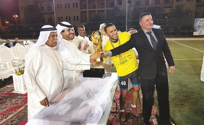 الشيخ دعيج الخليفة وحسين الشرهان يسلمان ابراهيم نمر وقائد فريق شركة مجدي كأس البطولة﻿