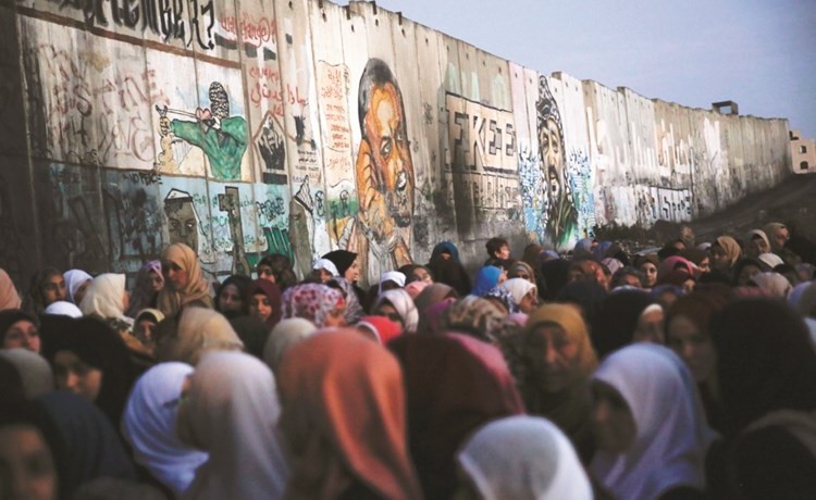 فلسطينيون في طريقهم للصلاة في الاقصى يمرون بجوار صور جدارية للاسرى عند نقطة تفتيش قلنديا بالضفة	(أ.پ)﻿