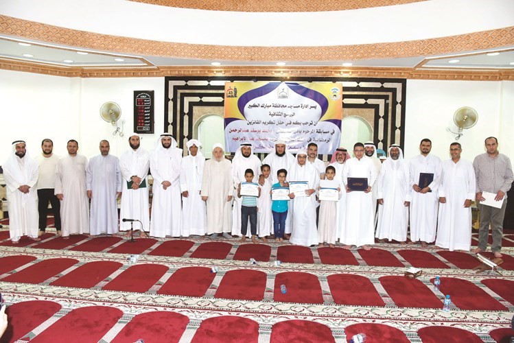 وليد الشعيب ويوسف عبدالرحمن وخالد عبداللطيف الشميس والشيخ مصطفى أبوحسين وجاسم المطوع ود.جمال الزنكي والشيخ محمد سرانك وإمام المسجد عصام العبيد والزميل محمد راتب في صورة جماعية مع عدد من المتسابقين﻿