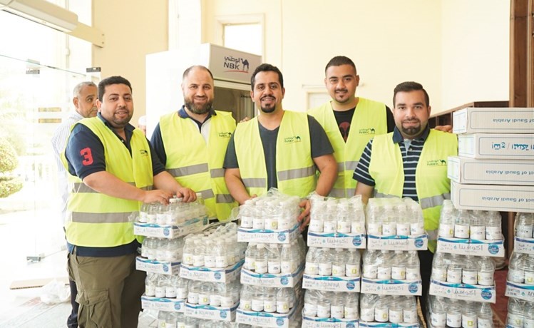 متطوعو البنك خلال توزيع المياه والتمور على المساجد﻿