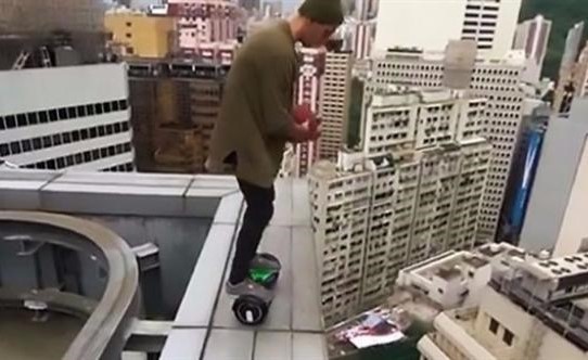 بالفيديو.. مغامر يركب السكوتر ويلعب كرة السلة على حافة ناطحة سحاب