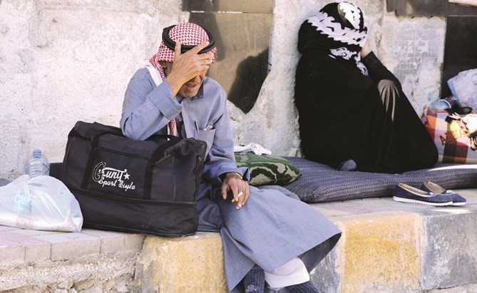 النازحون السوريون الذين هربوا مع عائلاتهم من الرقة ودير الزور في محطة حافلات راموس في حلب أمس الأول(أ.ف.پ)﻿