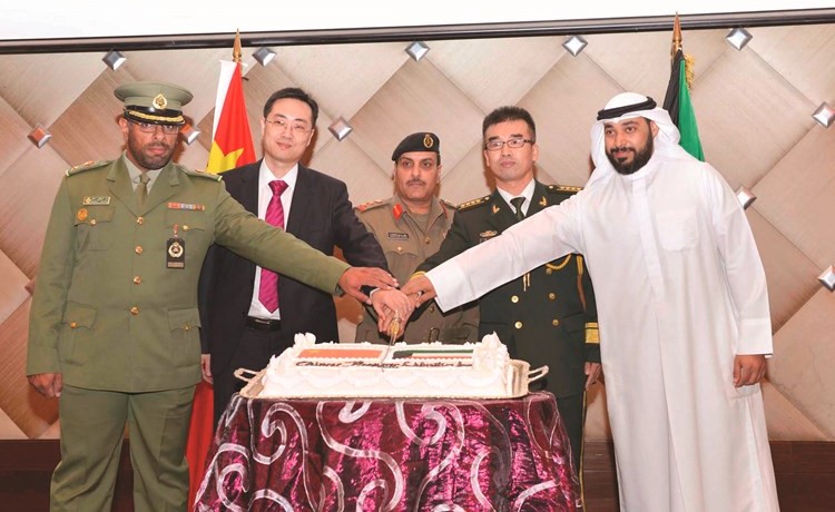 العقيد الركن خالد الشعلة والقائم بالأعمال الصيني تشاو ليانغ والملحق العسكري الصيني تشانغ قه خلال قطع كعكة الاحتفال﻿
