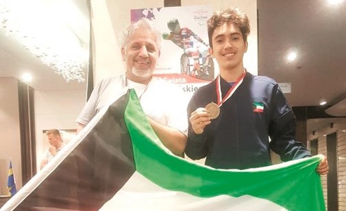 اللاعب عبدالله الخالدي حاملا ميداليته مع العلم﻿