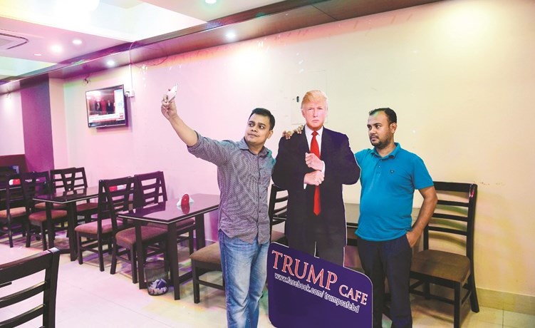 بنغاليان يلتقطان سيلفي مع مجسم للرئيس الامريكي دونالد ترامب في احد المطاعم التي تحمل اسمه بدكا(ا.ف.پ) ﻿