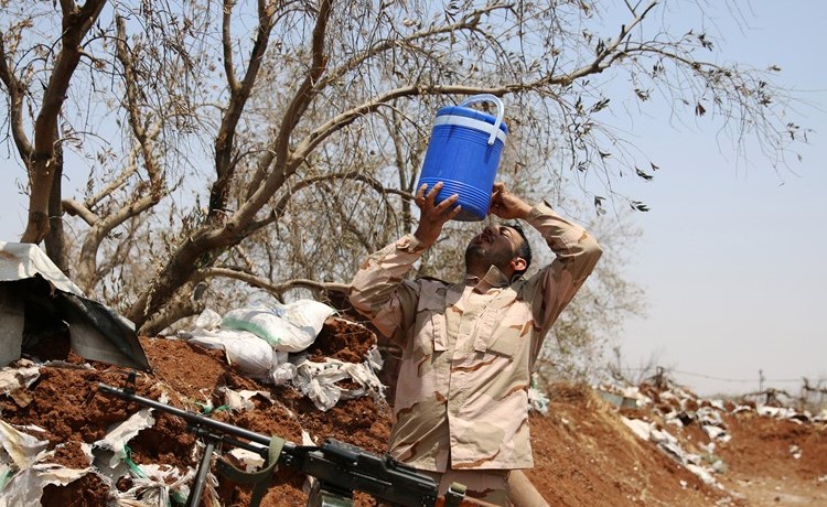 احد مقاتلي الجيش الحر يشرب الماء في قرية الغارية الغربية في محافظة درعا(رويترز) ﻿