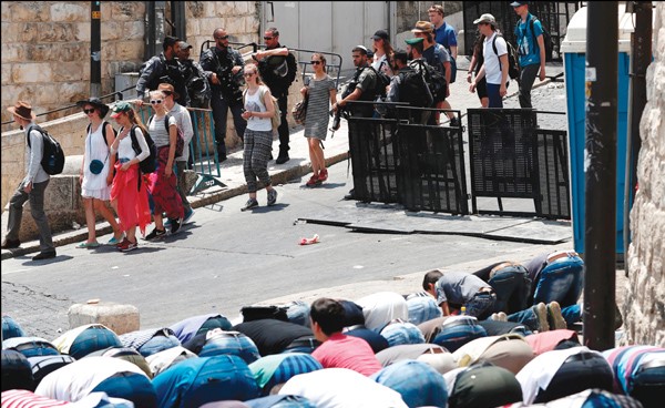 فلسطينيون يؤدون الصلاة عند بوابة الاسد امام المسجد الاقصى وسط تأهب من قوات الاحتلال  (ا.ف.پ)