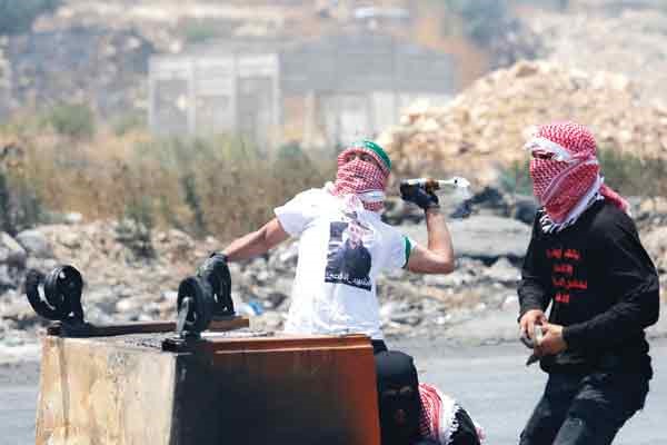 شاب فلسطيني يقذف قوات الاحتلال بقنبلة مولوتوف خلال مواجهات في رام الله امس 	(ا.پ)