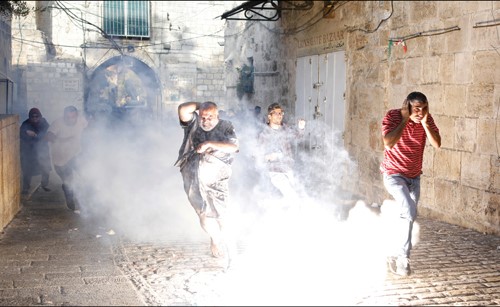 فلسطينيون يحاولون تجنب القنابل المسيلة ورصاص الاحتلال الاسرائيلي في القدس القديمة	(رويترز)