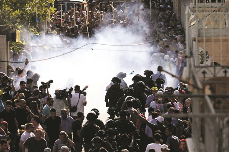جنود الاحتلال يلقون القنابل المسيلة للدموع لمنع جموع الفلسطينيين من دخول الأقصى(رويترز)