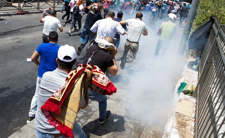 مصلون يفرون من قنابل الغاز المسيل للدموع التي أطلقها الاحتلال عليهم عقب صلاة الجمعة خارج الأقصى(أ.پ)﻿