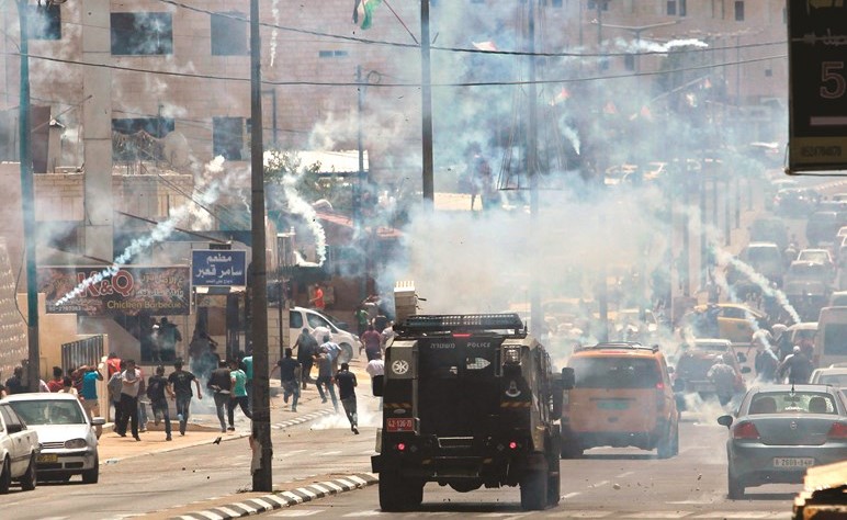قوات الاحتلال تطلق قنابل الغاز لتفريق الفلسطينيين عقب صلاة الجمعة في بيت لحم أمس	(ا.ف.پ)﻿