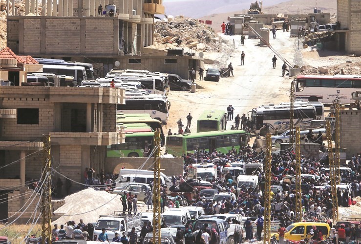 آلاف اللاجئين السوريين المبعدين الى ادلب ينتظرون صعود الحافلات(ا.ف.پ)﻿