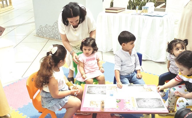 فاطمة الأمير مع عدد من الأطفال بمعرض الأطفال ﻿