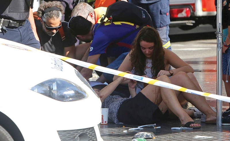 محاولة اسعاف المصابين الذين سقطوا نتيجة العمل الإرهابي في شارع «لاس رامبلاس» السياحي وسط برشلونة أمس	 (أپ)