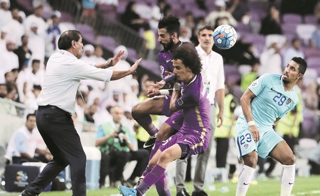 مدرب الهلال رامون دياز يحاول تفادي الاصطدام بلاعبي العين محمد عبدالرحمن وبندر الاحبابي(أ.ف.پ) ﻿