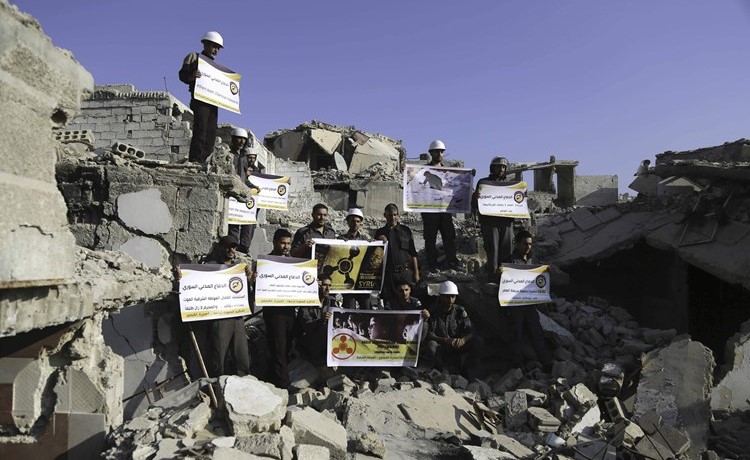 عناصر من الخوذ البيضاء يحيون الذكرى الرابعة للهجوم الكيماوي على غوطة دمشق في مدينة زملكا	(أ.ف.پ)﻿