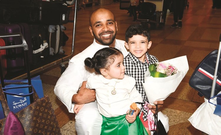 احد الحجاج يحمل طفليه لحظة وصوله المطار﻿