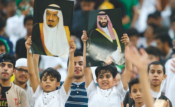 الجماهير السعودية ترفع صور خادم الحرمين وولي عهده في المدرجات (أ.ف.پ)