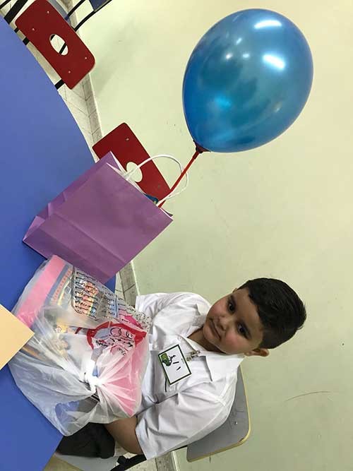 تعليق بطاقة تعريفية على صدر الطالب مع استلامه لكتبه