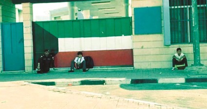 وكيل عريف مشاري المطيري اثناء جلوسه مع الطفلين بانتظار ذويهما﻿