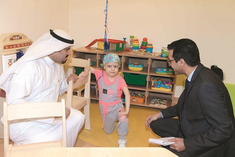 د.عبدالرحمن الدوسري والزميل عبدالكريم العبدالله مع طفلة خلال الجولة﻿