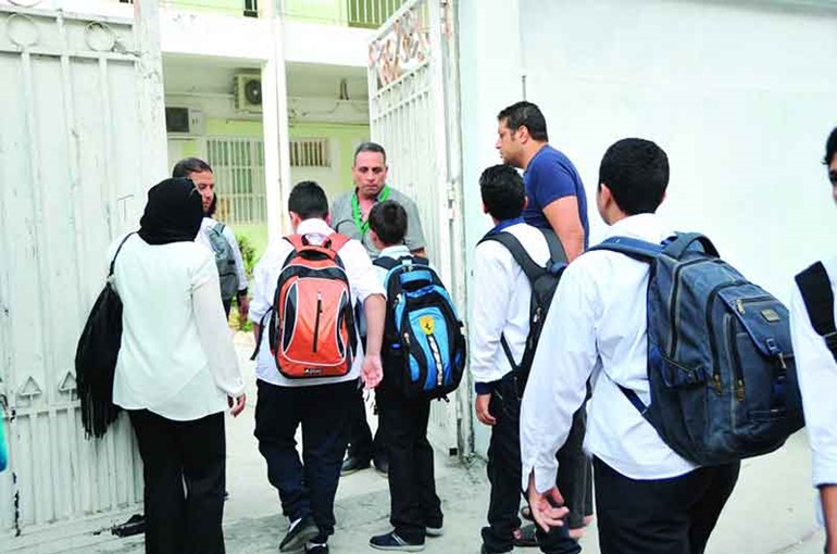 عدد من طلبة مدرسة النجاة الثانوية لدى دخولهم المدرسة﻿