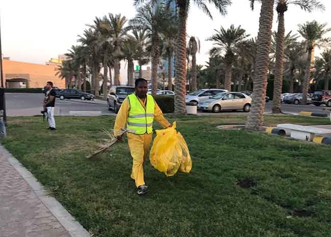 أحد عمال البلدية خلال رفعه الأنقاض من على الشاطئ المارينا