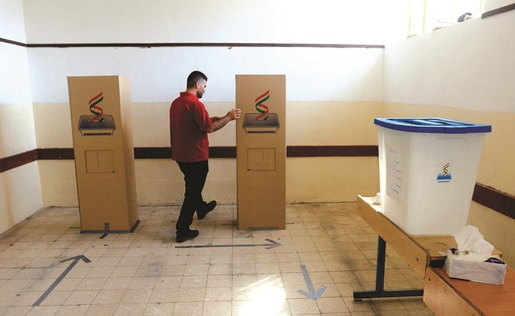 موظف كردي يجهز صناديق الاقتراع للاستفتاء المقرر اليوم في أربيل	(رويترز)﻿