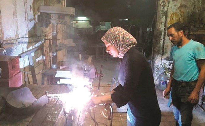 سيدة تعمل في الحدادة وتنافس الرجال