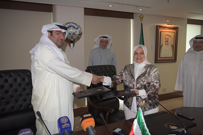 وزير التجارة والصناعة خالد الروضان ووزيرة الشؤون الاجتماعية والعمل هند الصبيح خلال توقيع الاتفاقية (محمد هنداوي)